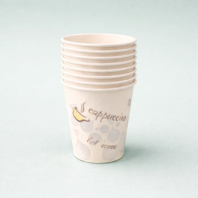 Stack of paper cups with cappuccino and hot cocoa text on a light gray background