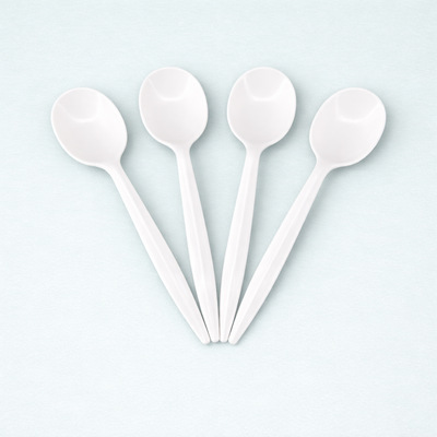 Four disposable white spoons arranged in a star shape on a light blue background